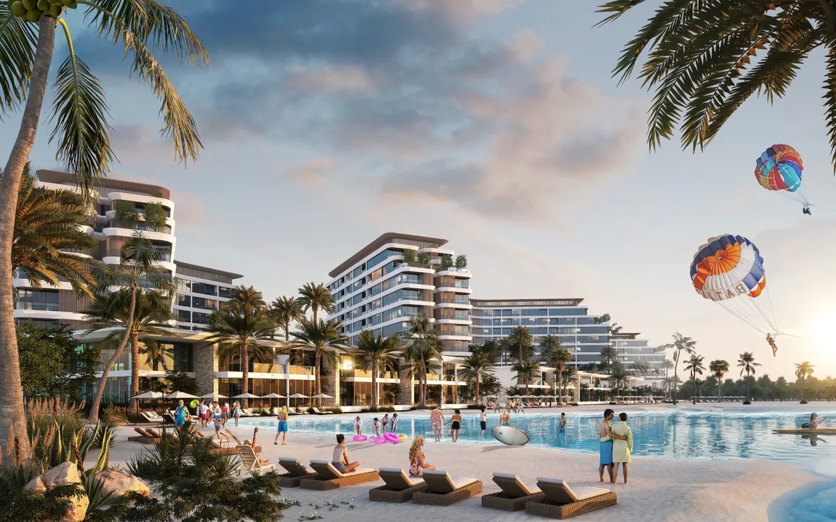 Apartment buildings over the sports lagoon, with a beach and paragliders
